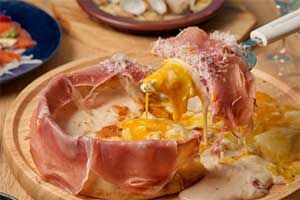 株式会社THANが運営する居酒屋業態『原価ビストロチーズプラス』名物メニュー『生ハム温玉シカゴピザ』