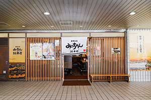 広島流お好み焼みっちゃん総本店の店頭。のれんには「お好み焼みっちゃん井畝満夫(いせ みつお)の店」。